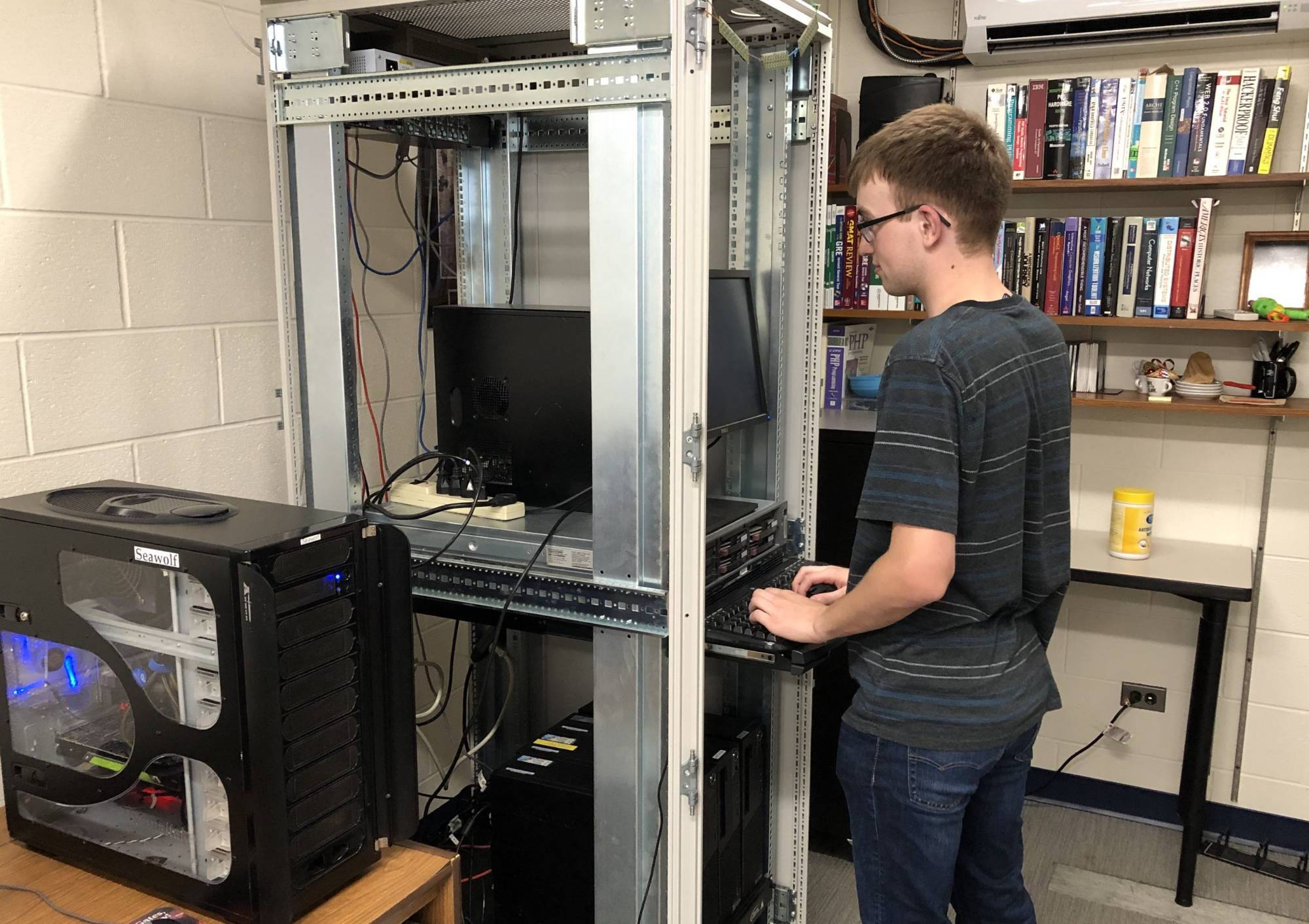 photograph of student with machine inside DEN lab